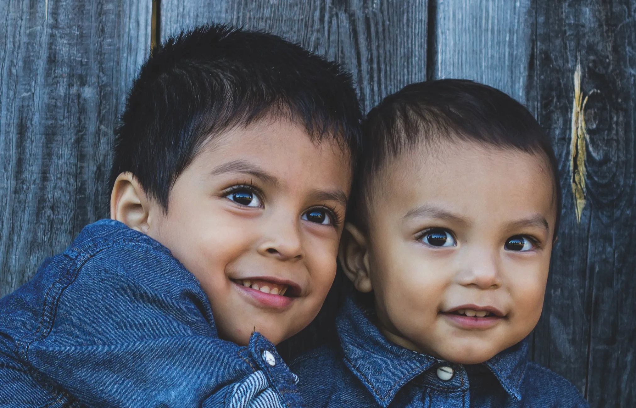 two latino children hugging on a stair case