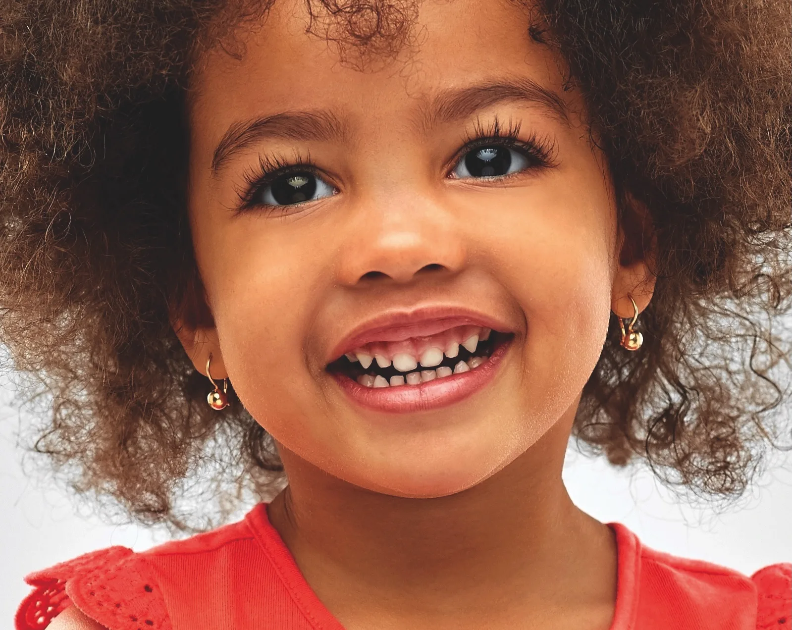 childhood and people concept - happy little african american girl over grey background